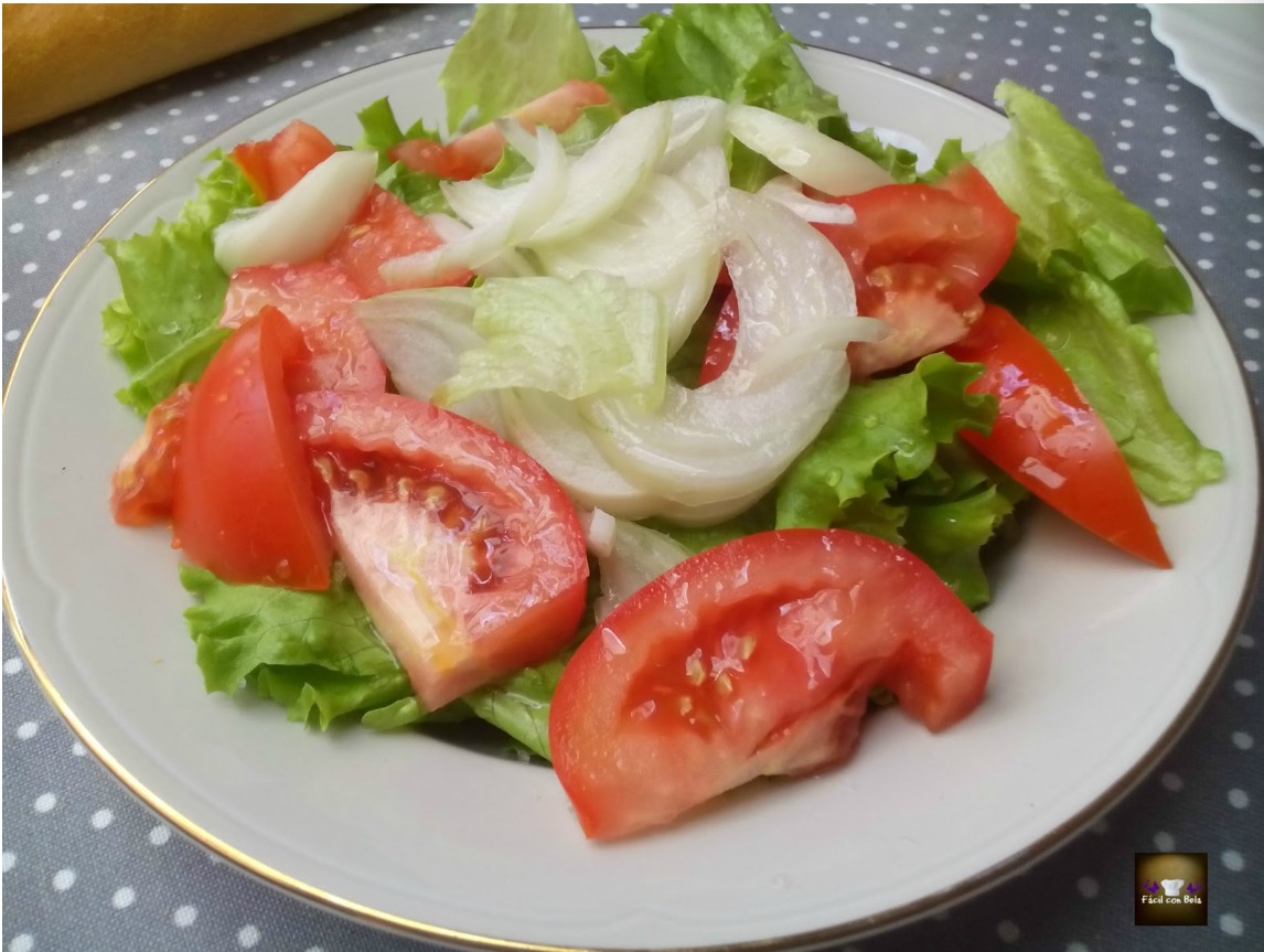 Ensalada de lechuga,cebolla y tomate con salchichas al vino